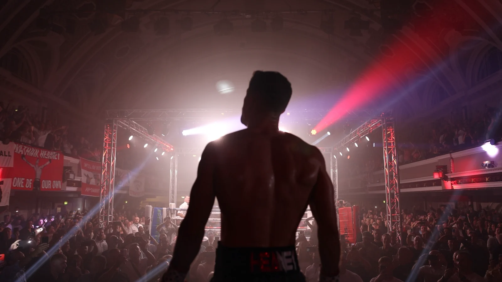 Nathan Heaney walking towards the boxing ring at Kings Hall, surrounded by supporters