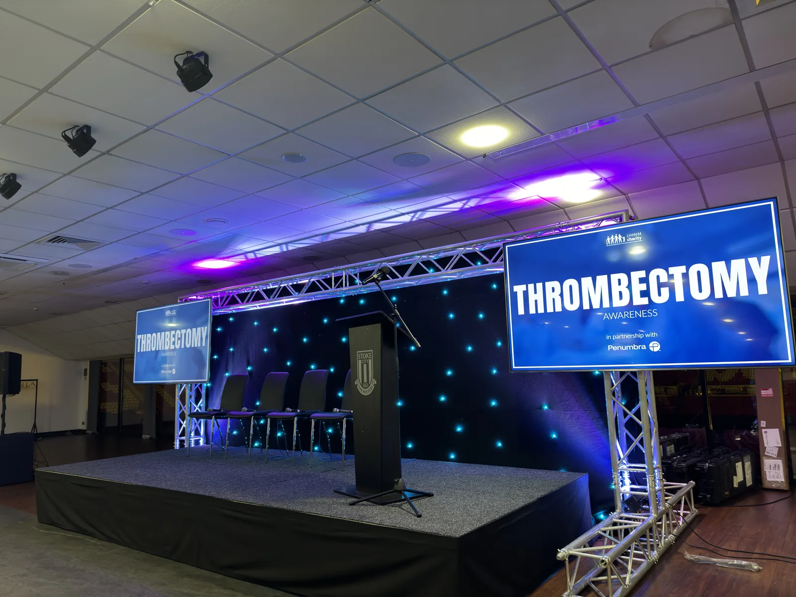 Conference stage with truss, lighting and presentation screens