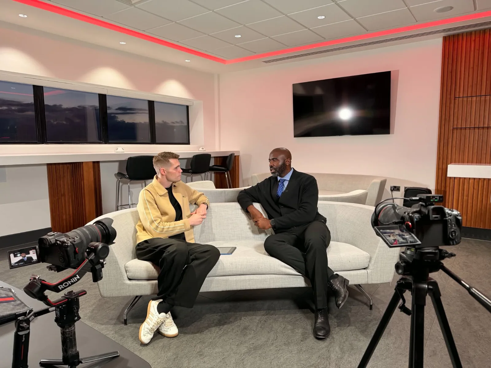 Two participants being filmed with a multi-camera interview setup