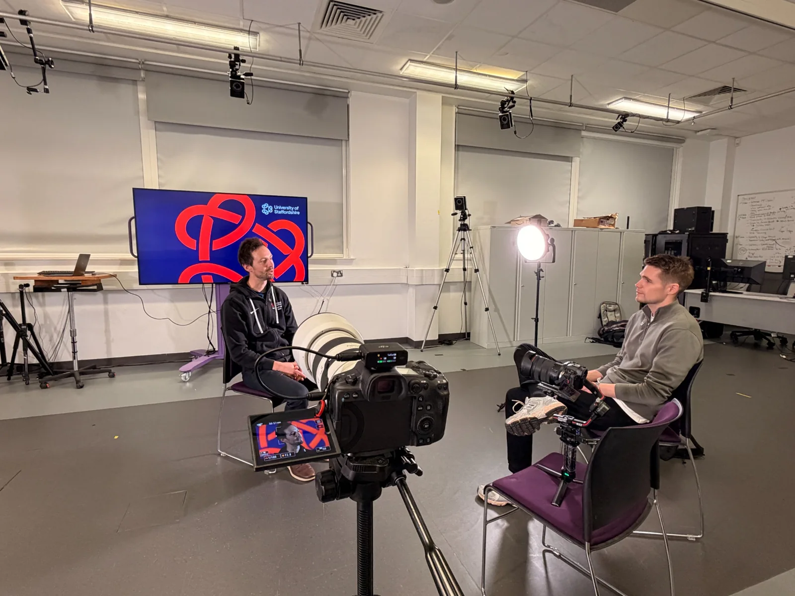 Cameras, microphones and lighting prepared for a studio conversation